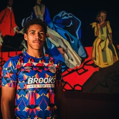 A young man wearing the Black History Month Cambridge United shirt