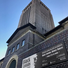 Exterior view of Cambridge University Library with a freestanding exhibition display board positioned in front of the building