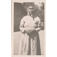 Portrait of Lucy Young (T’tc~tsa) standing outdoors, wearing a long dress and headscarf, photographed in California, 1922