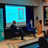 Nicolas Bell-Romero and Pedro Ramos Pinto seated on a small stage in discussion