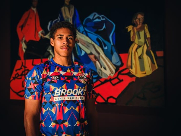 A young man wearing the Black History Month Cambridge United shirt