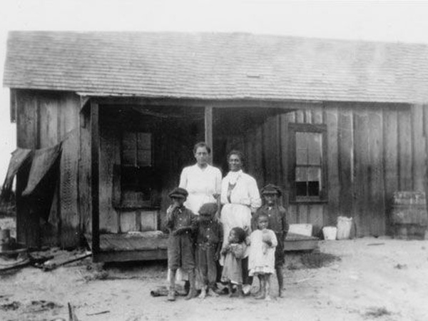 Early twentieth-century African American family standing outside a wooden home in Blackdom, New Mexico, one of the best-known Black towns founded after emancipation.