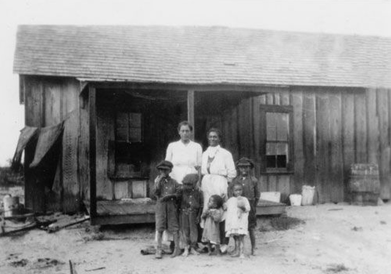Early twentieth-century African American family standing outside a wooden home in Blackdom, New Mexico, one of the best-known Black towns founded after emancipation.
